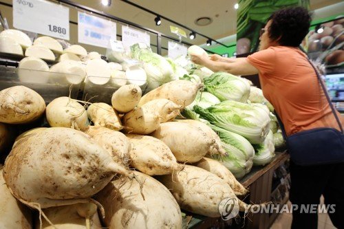 한 도매시장에서 소비자가 농산물을 고르고 있다. [연합뉴스]