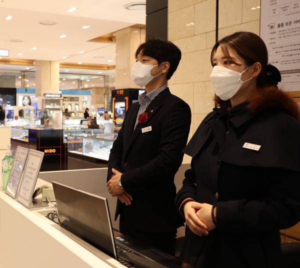 롯데백화점 1층 안내 데스크 직원들이 마스크를 착용하고 근무하고 있다.